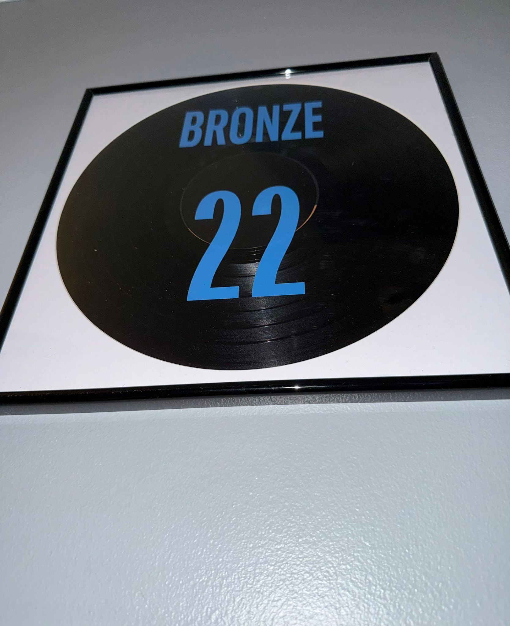 75) Lucy Bronze Framed Vinyl Art 12”